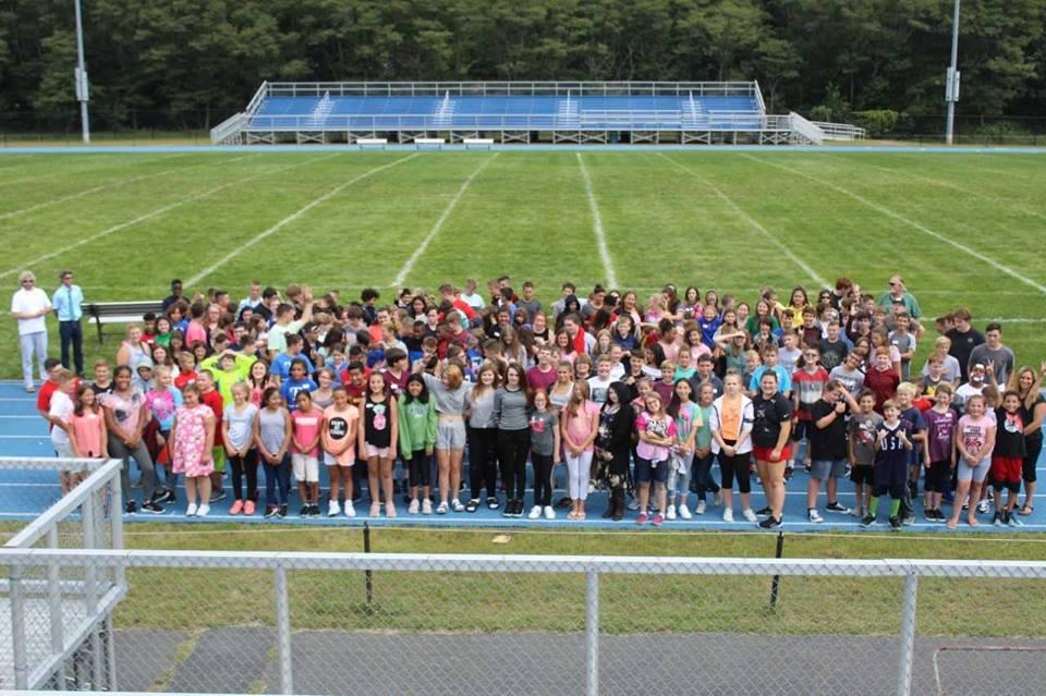 large group of middle school students assembled on a football field